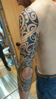 Tatuaje en blanco y negro de una manga tribal en el brazo