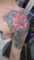 Tatuaje de unas flores a color en el hombro