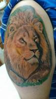 Tatuaje de una cabeza de león a color, en el brazo