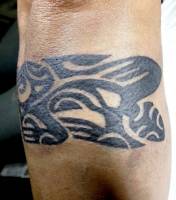 Tatuaje de un lagarto maori haciendo un brazalete