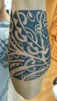 Tatuaje en el antebrazo de un brazalete maorí