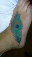 Tatuaje a color de una pluma de pavo real en el pie
