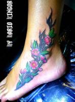 Tattoo de una rama con flores en el pie