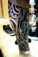 Tattoo en la pierna de un brazalete maorí en blanco y negro