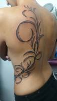 Tatuaje de una planta en la espalda de una chica