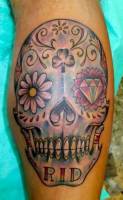 Tatuaje a color de una calavera mexicana con ojos de flores  y elementos de poker