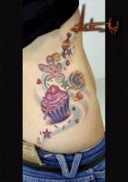 Tatuaje a color de galletas y dulces en la cintura