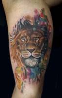 Tatuaje de una cara de león con pinceladas de colores