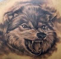 Tatuaje de una cabeza de lobo rugiendo