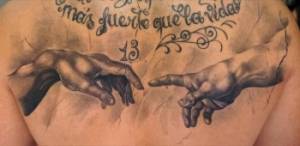 Tatuaje de las manos de la capilla sixtina y una frase en la espalda