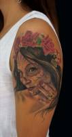 Tattoo de una chica pintada de calavera de azúcar con flores en la cabeza