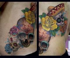 Tatuaje de calaveras mexicanas con rosas en la cintura