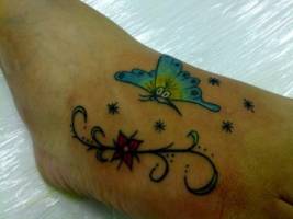 Tatuaje de una mariposa junto unas estrellas y una flor