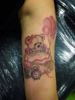 Tatuaje de un oso de peluche sujetando unos globos