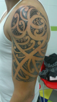 Hombro y brazo tatuado con tribal