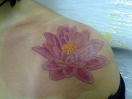 Hombro de chica tatuado con flor de loto