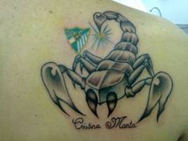 Tatuaje de un escorpión con el escudo del Málaga y un nombre