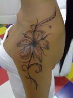 Tatuaje de una flor en el hombro de una chica