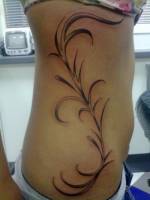 Tatuaje de una planta en el costado de una chica