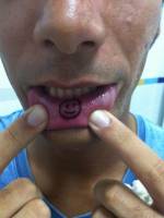 Tatuaje de una smily en el labio