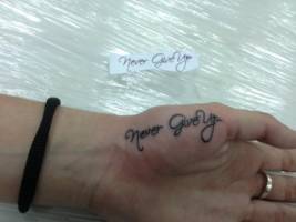 Tatuaje de la palabra Never Give up en la mano
