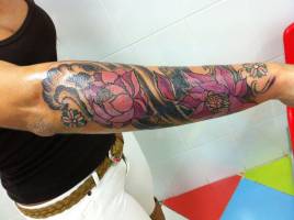 Tatuaje de flors y viento en el antebrazo