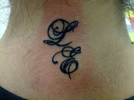 Tatuaje de dos iniciales en la nuca