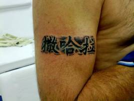 Tatuaje de unas letras chinas en el brazo