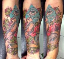 Tatuaje de un ojo de Horus, un pájaro en una rama y una brújula