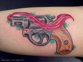 Tatuaje de una pistola con un corazón