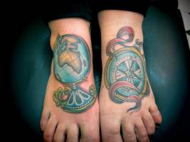 Tatuaje de un globo terraqueo y una brújula en los pies