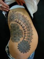 Tatuaje de flores geométricas en la cintura de una chica