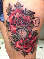 Tatuaje de un reloj entre rosas rojas