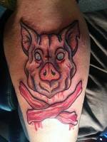 Tatuaje de la cabeza de un cerdo con bacon debajo