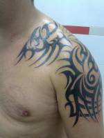 Tatuaje de un tribal en el brazo y deltoides