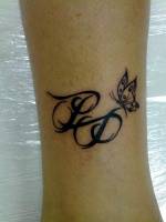 Tatuaje de dos iniciales y una mariposa