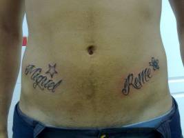 Tatuaje de dos nombres en la cintura de un hombre