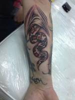 Tatuaje de una serpiente escondiendose dentro de la piel