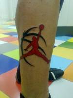 Tatuaje del logo de Air Jordan con una pelota de baloncesto detras