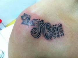 Tatuaje del nombre Meggy con flores, estrellas y la fecha de nacimiento