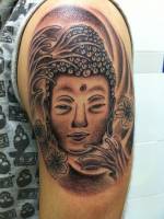 Una cabeza de buda tatuada en el brazo