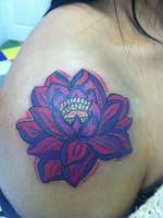 Flor de loto tatuada en el hombro