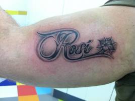 Tattoo del nombre Rosi con una flor en el interior del brazo