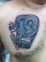 Tattoo de una maquina de tatuar y una calavera deforme