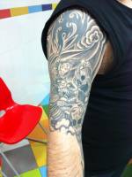 Tatuaje de un dragón agarrando calaveras