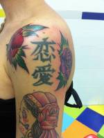 Tatuaje de unas letras chinas entre dos rosas y una  calavera mexicana