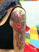 Tatuaje de una rosa, una telaraña con letras chinas y una calavera mexicana