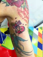 Tatuaje de cerezas con un lazo