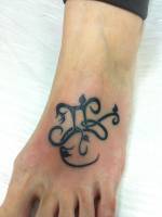 Tatuaje en el pie de un simbolo con hojas