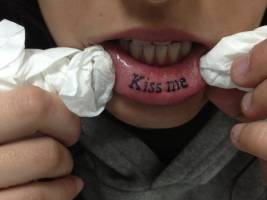Tatuaje de la paraula Kiss me en el labio